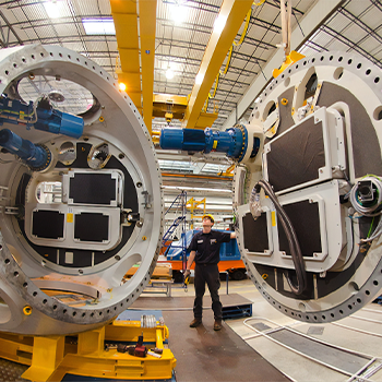 Man standing between two giant machines